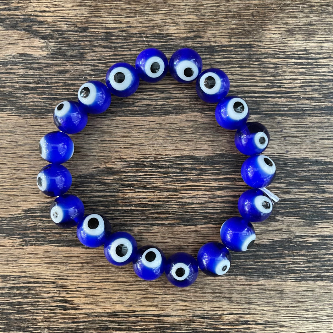Handmade personalised beaded name bracelet. Glass beads and smiley with  acrylic letters and a ceramic evil eye bead. Blue, black, yellow.